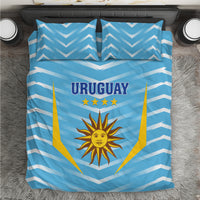 Blue Uruguay bedding set viewed from above with chevron stripes, sun crest, and stars