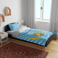 Blue Uruguay bedding set on bed with matching pillows, sun crest, and “URUGUAY”
