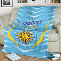 Uruguay football blanket covering couch, light blue chevrons with URUGUAY sun emblem