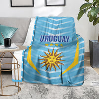 Uruguay football blanket on armchair, light blue chevrons with sun emblem and yellow flag