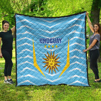 Light blue Uruguay football quilt spread on grass, 'URUGUAY' with sun emblem and stars
