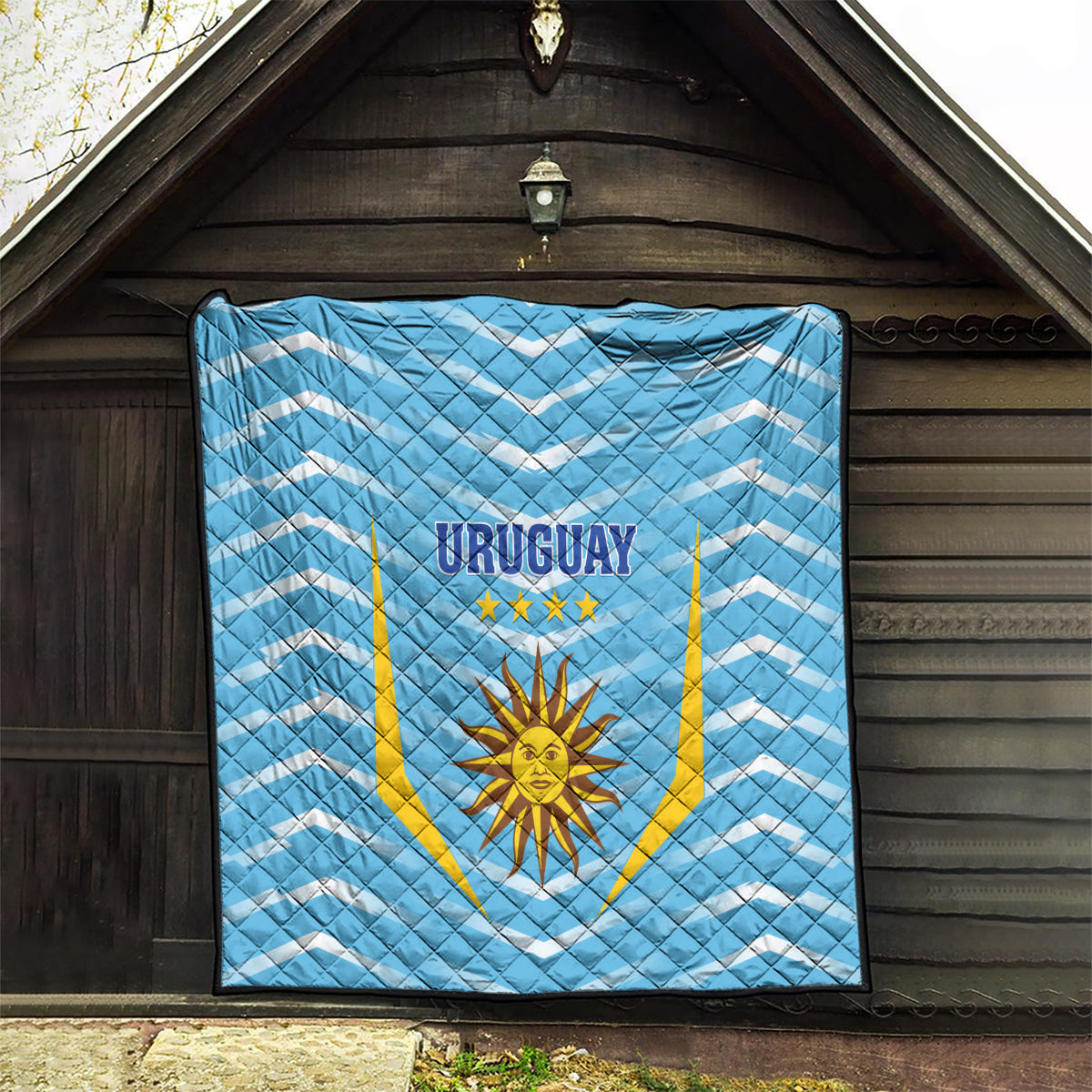 Light blue Uruguay football quilt hung on a wall, 'URUGUAY' and star sun emblem