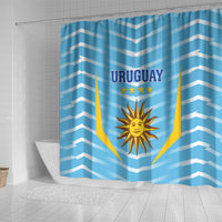 Blue shower curtain with chevron pattern and Uruguay crest centered on fabric