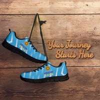 Light blue football sneakers with Uruguay crest, black sole, angled side view