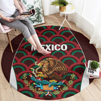 Round football carpet laid on floor, “MEXICO” text over eagle emblem with red-green waves.