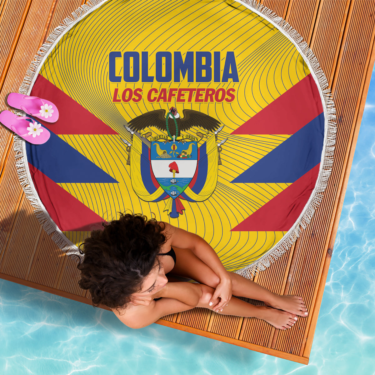 Round yellow beach blanket with crest and bold blue/red diagonals, white tassel fringe