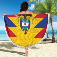Round beach blanket held overhead with Colombia crest, yellow swirl rays, blue and red panels, fringe