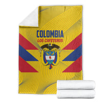 Colombia football blanket with folded stack of white towels, yellow with blue/red crest design
