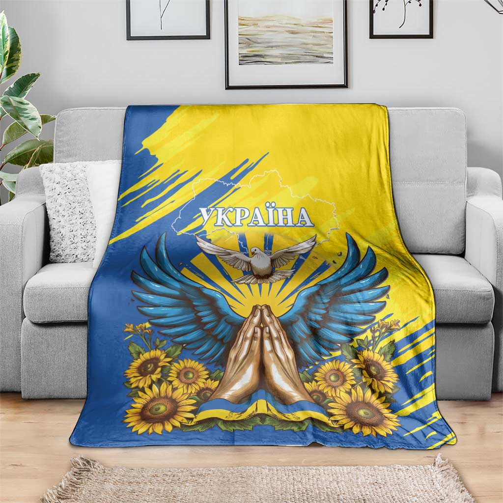 Blue and yellow Ukraine dove and sunflower blanket shown folded over a sofa