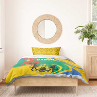 Bedding set on bed: yellow pillow shams and green duvet with crest, blue swirls, and lions