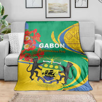 Gabon independence day blanket draped on sofa, green and yellow field with blue border and animals