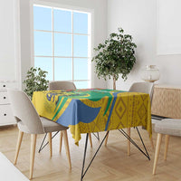 Patterned tablecloth with green, blue, and yellow geometric and animal motifs