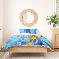 Blue bedding set with sun emblem and 25 August, neatly styled with two pillowcases