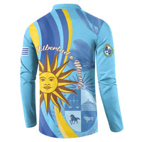 Light blue button sweatshirt with bold sun graphic and Uruguay emblem on back