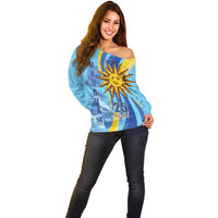 Women’s light blue off-shoulder sweater with sun and 25 August graphic, front view