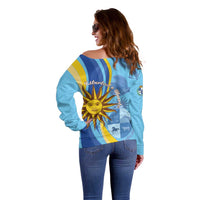 Women’s light blue off-shoulder sweater, back view, sun graphic and flag stripes