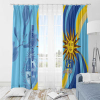 Blue window curtain set with sun face and “25 August” text, plus “URUGUAY” vertical panel.