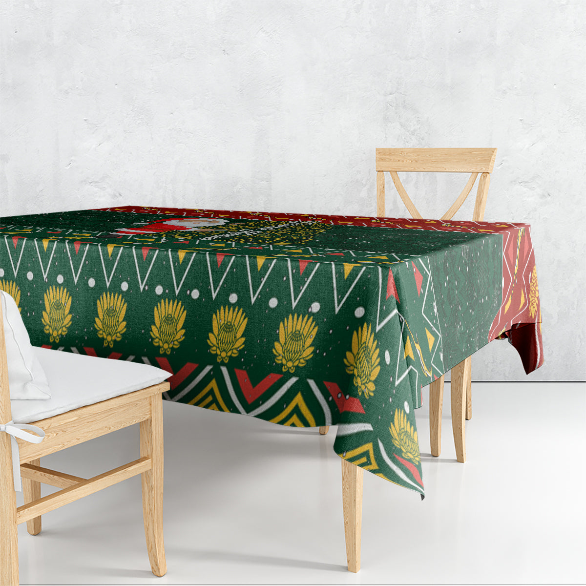 Green Christmas tablecloth with repeating geometric and floral motifs, draped over table