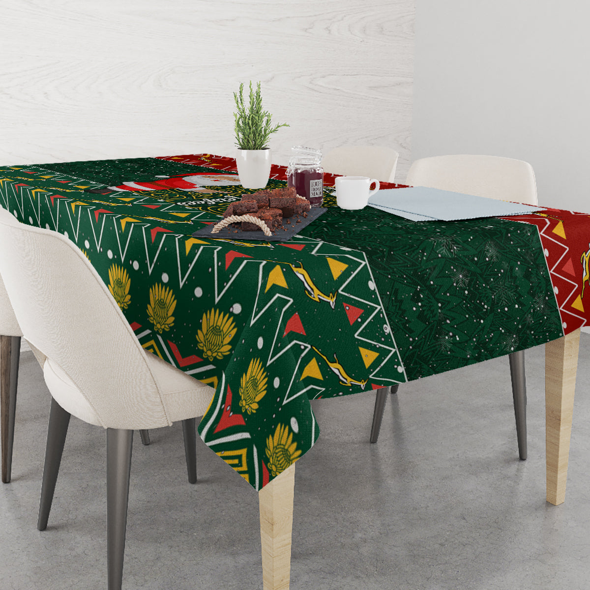 Green Christmas tablecloth spread across table with gold floral and zigzag pattern