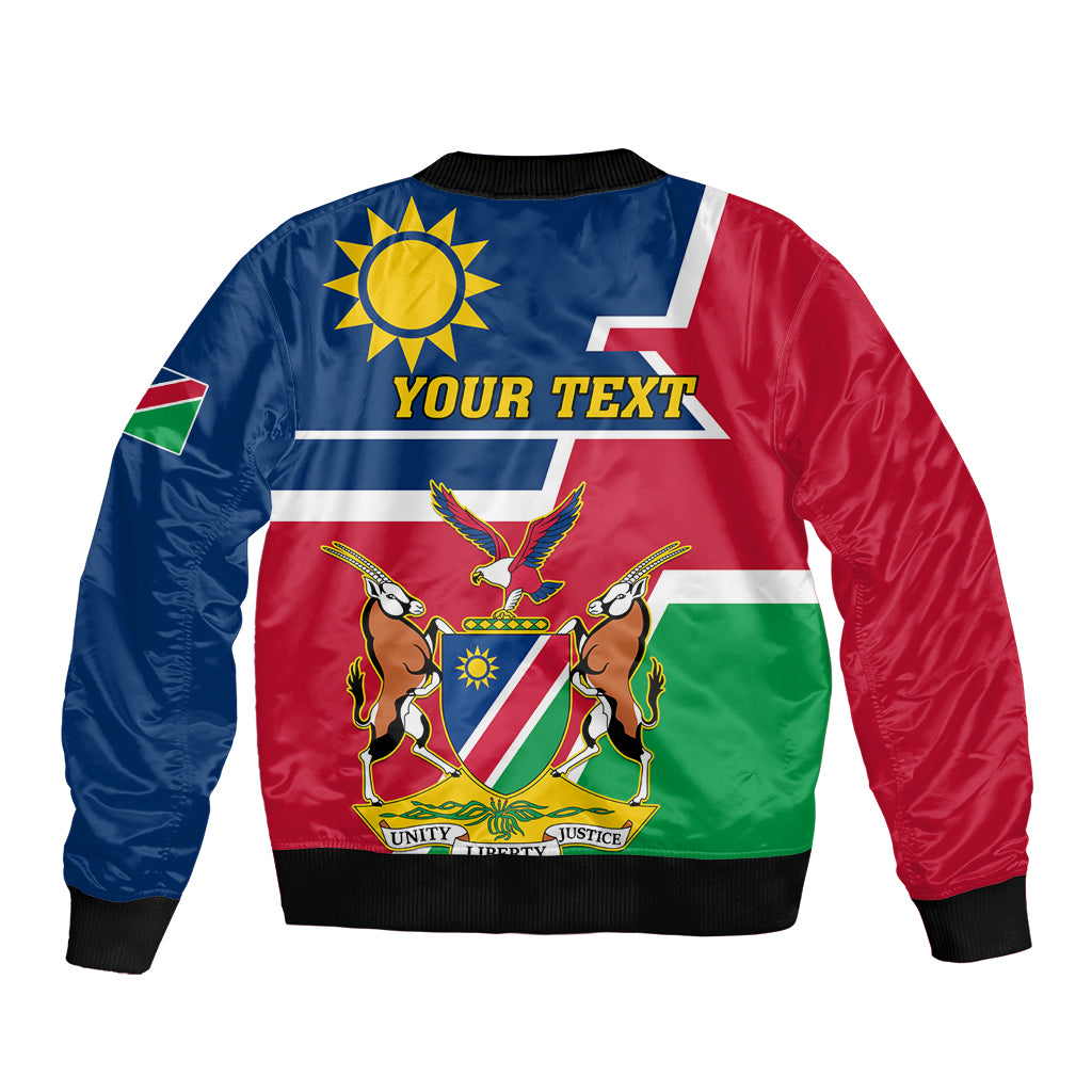 Blue, red, and green Namibia-style bomber jacket with sun-and-emblem graphic and “YOUR TEXT”