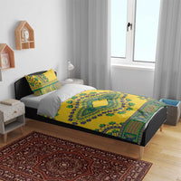Yellow dashiki duvet and pillowcases with green and blue border pattern on a bed