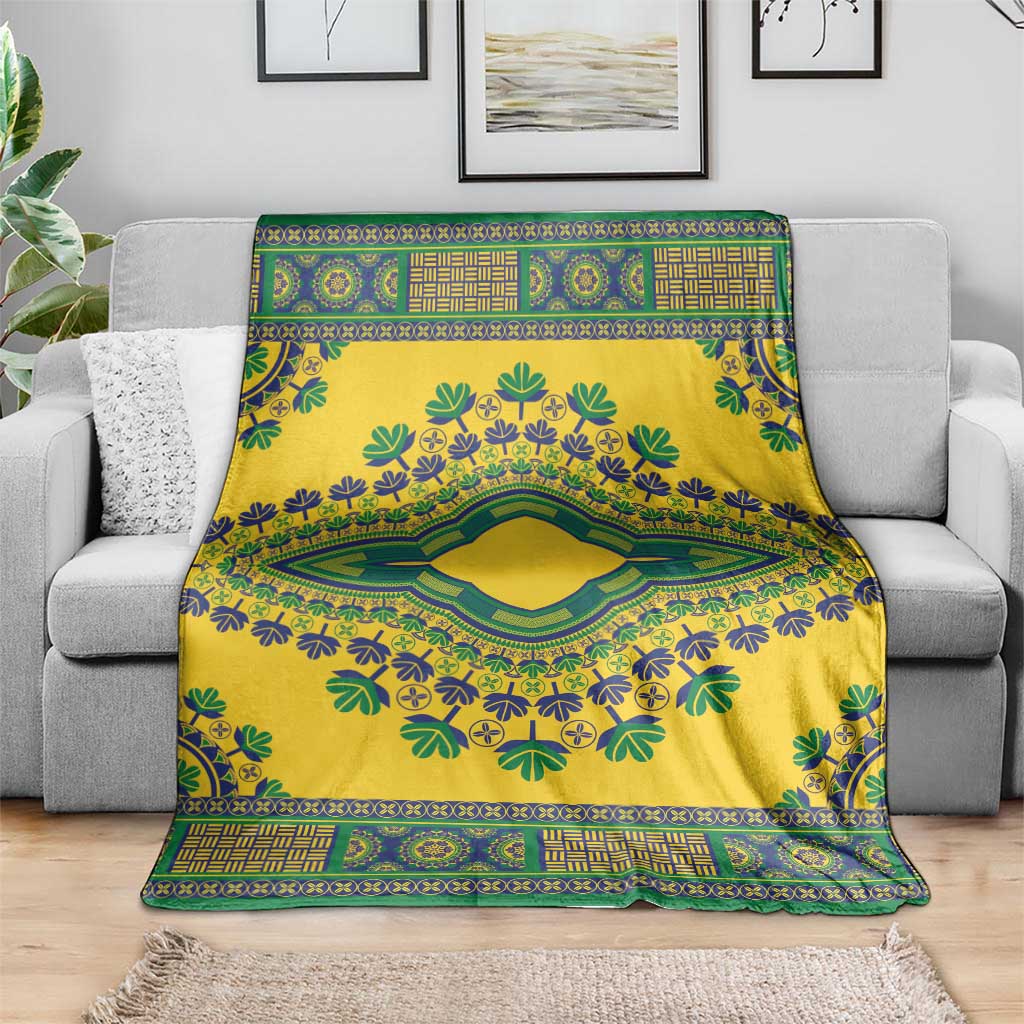 Yellow dashiki blanket with green and blue floral motif, spread over a gray sofa.