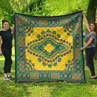 Yellow and teal-green decorative quilt with border motifs and central medallion