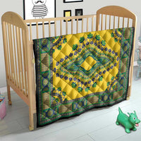 Yellow quilt on a child crib with teal-green ornate border and center medallion