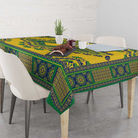 Yellow dashiki tablecloth draped over table edge, teal-green patterned border