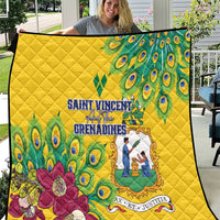Yellow quilt held outdoors, peacock feather pattern with central emblem and flowers