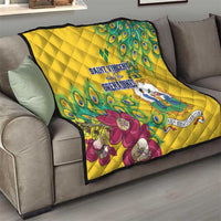 Yellow quilt draped on sofa, peacock feather print with large flower and emblem
