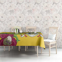 Yellow tablecloth on console table with peacock feather and magenta floral pattern