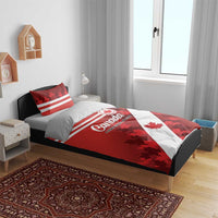 Red Canada bedding set with maple leaf flag print, white stripes, and two pillows