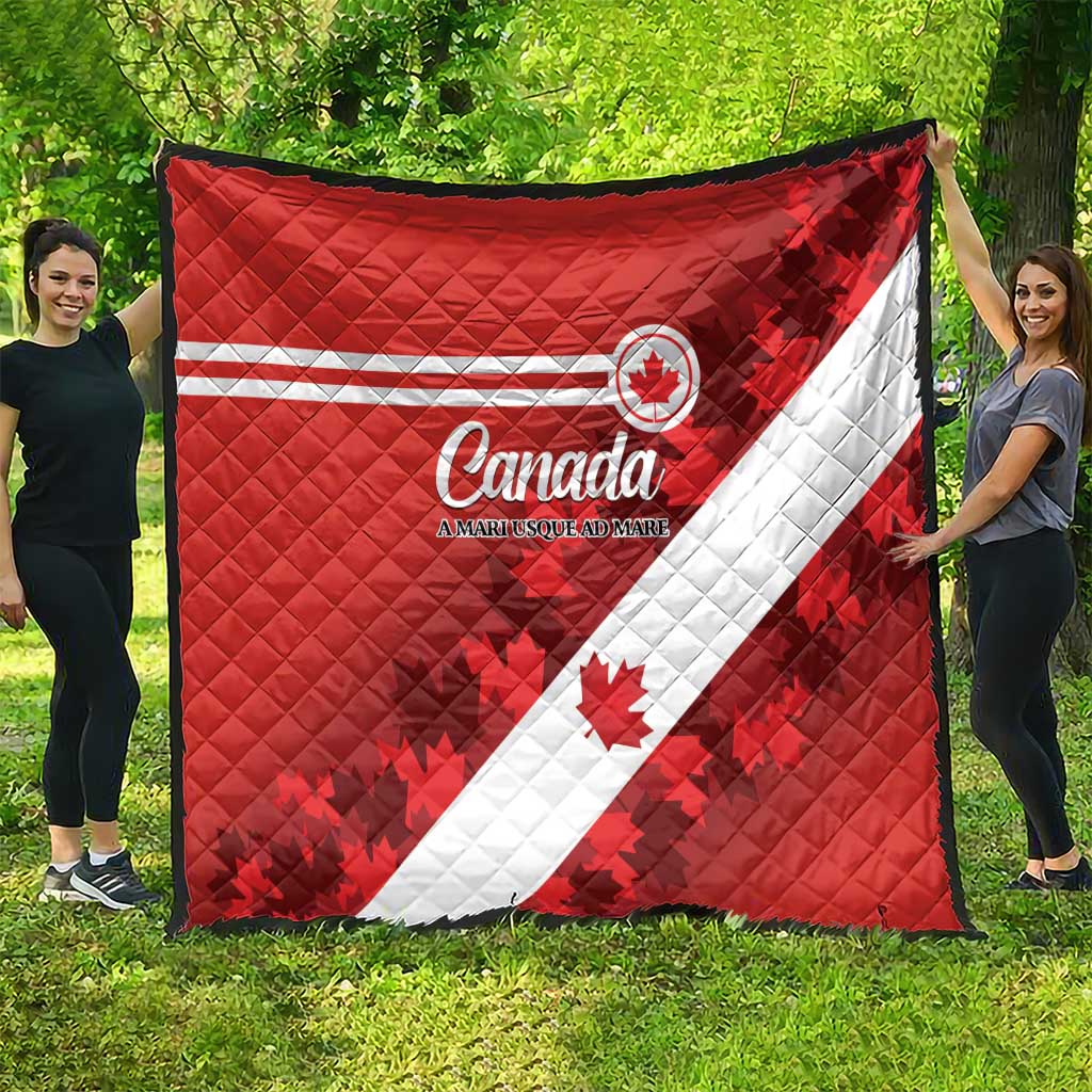 Red Canada quilt laid out outdoors, white diagonal band and maple leaf graphics