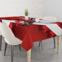 Red tablecloth with white band and scattered maple leaves over dining table