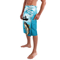 Blue fish-print lavalava with centered tuna graphic, side view, elastic waistband