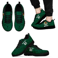 Green football sneakers pair with black soles, Mexico crest on sides, lace-up.