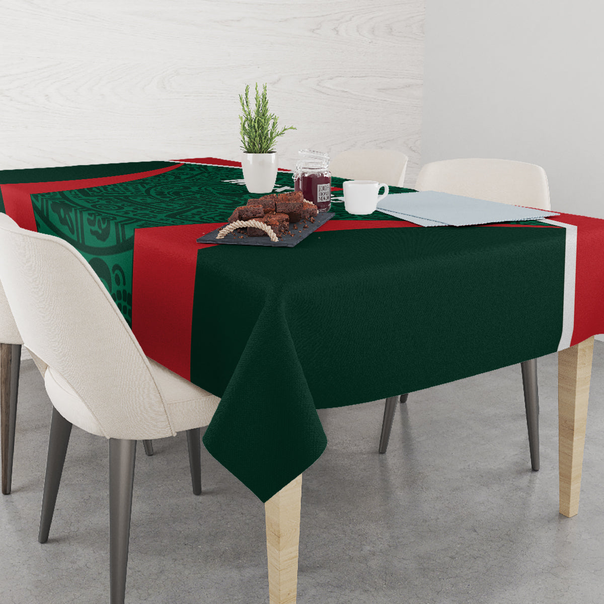 Green tablecloth with red stripe and patterned center, laid across table with dishes