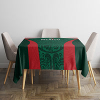 Green tablecloth with red accents and geometric Mexico-style print on dining table