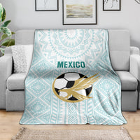 Mint Mexico football blanket with eagle-soccer emblem and geometric design on gray sofa