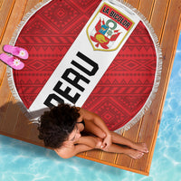 Round beach blanket with red geometric pattern, white fringe border, 'PERU' sash graphic