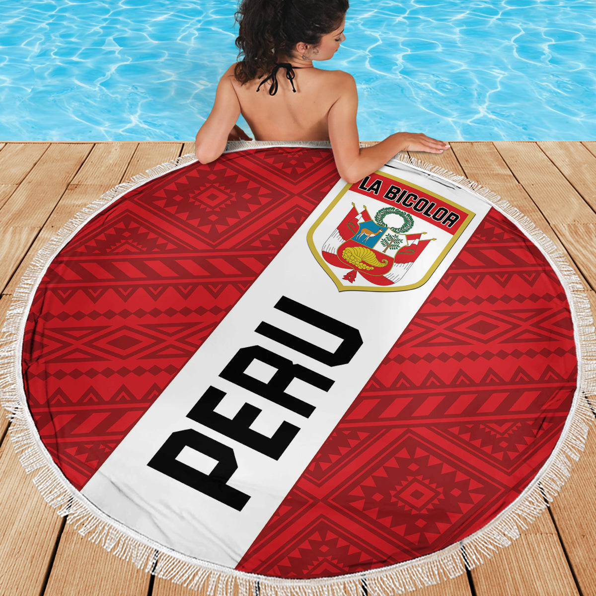 Round beach blanket with red geometric center, white fringe edge, large 'PERU' banner