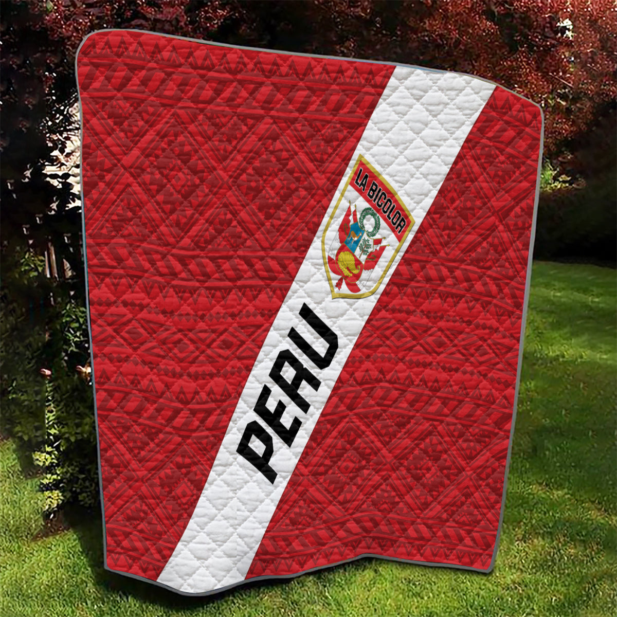 Red Peru football quilt blanket with quilted diamond pattern, diagonal white sash, and crest