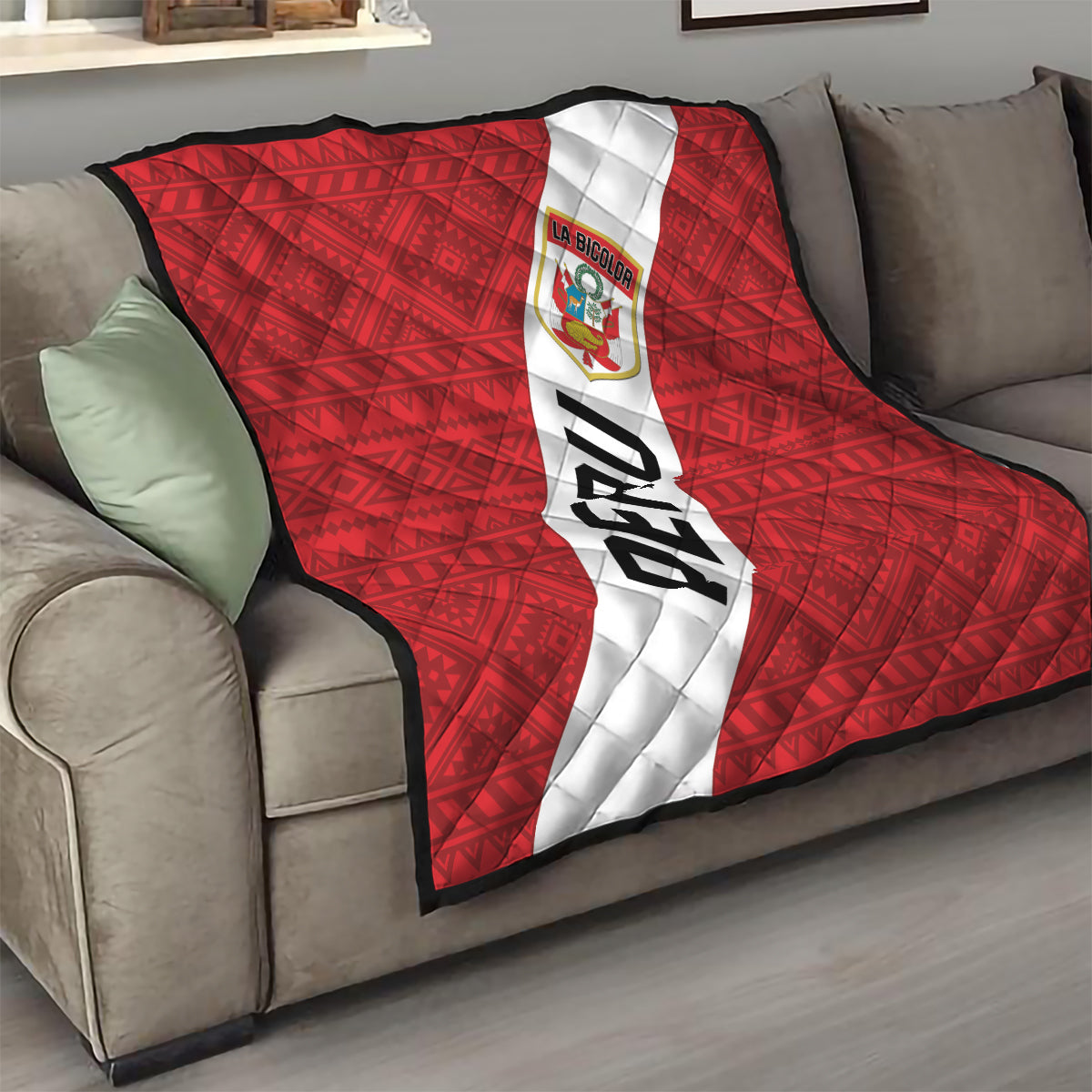 Red throw Peru football quilt on sofa with white diagonal stripe, crest logo, and PERU text