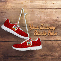 Red lace-up football sneakers with white sole and crest emblem on patterned upper.