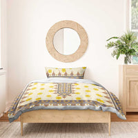 Yellow floral and geometric bedding set with duvet and pillowcases against a light wall.