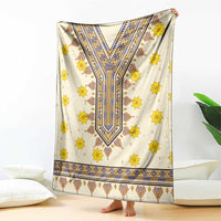 Cream blanket with yellow flowers and blue V-shaped geometric dashiki pattern, draped