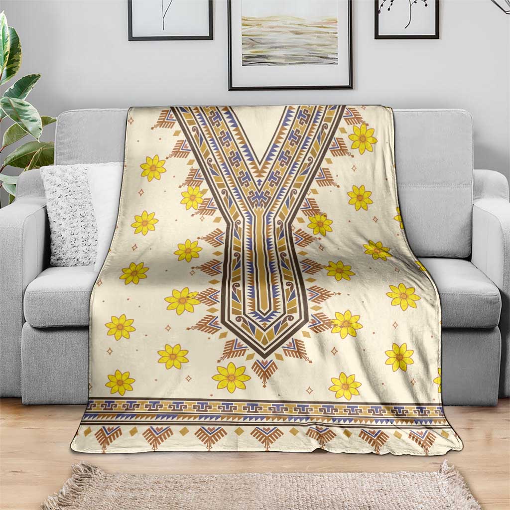 Cream blanket with yellow floral motifs and blue tribal stripe dashiki pattern on sofa