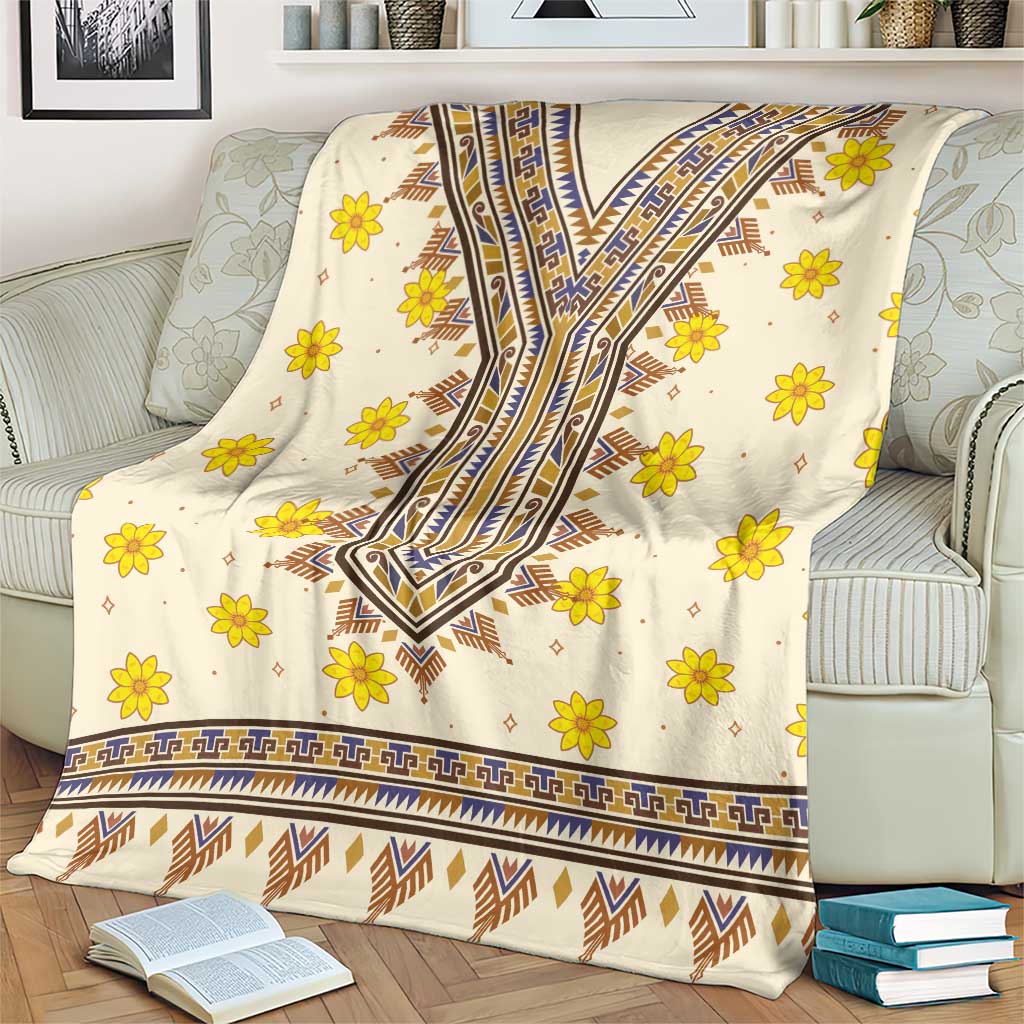 Cream dashiki pattern blanket with yellow flowers and blue trim along the hem
