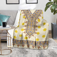 Cream blanket with yellow flowers and blue geometric dashiki center, on chair